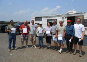 Graduates holding diplomas after completing CDL course